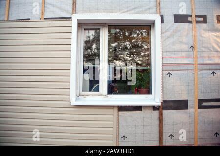 Revêtement mural de la maison de cadre avec panneaux de revêtement en vinyle de couleur grise. Décoration de la maison avec parement. Le maître met à jour l'apparence de la vieille maison avec voie d'évitement. Banque D'Images