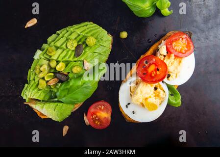 Toasts de patate douce avec avocat, œufs durs, tomates et graines de sésame sur fond sombre. Concept de repas sain. Cuisine propre, plats du Pescetarian, vue sur le dessus Banque D'Images