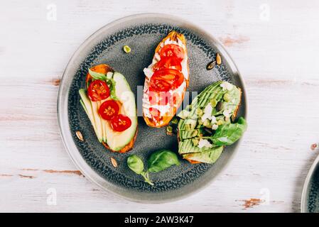 Toasts de patate douce avec avocat, œufs durs, tomates et graines de sésame sur fond rustique blanc. Concept de repas sain. Cuisine propre, plats du Pescetarian, vue sur le dessus Banque D'Images