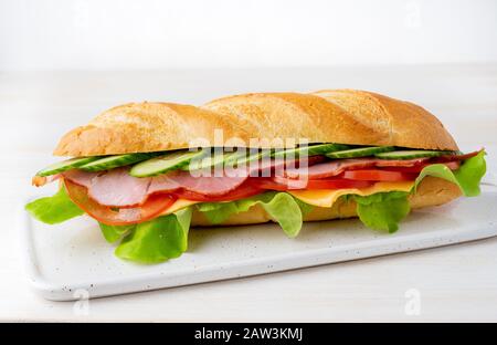 sandwich au jambon, au fromage, aux tomates, aux concombres, à la laitue sur fond blanc Banque D'Images