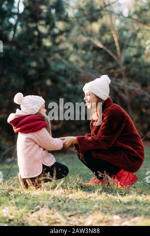 La mère et la fille jouent, se tiennent les mains et rigolent pendant la promenade dans la forêt. Banque D'Images