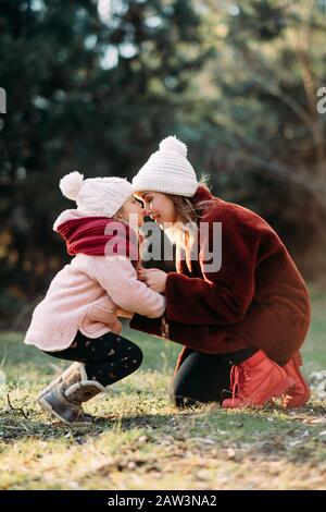 La mère et la fille jouent et s'amusent tout en marchant dans la forêt. Banque D'Images