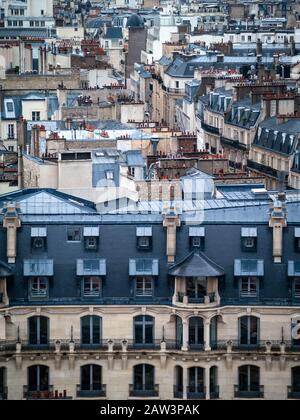 Paris, France vue aérienne sur les vieux bâtiments classiques traditionnels de la ville toits humides, une journée d'hiver pluvieux. Banque D'Images