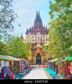 Bagan, MYANMAR - 25 FÉVRIER 2018: La ruelle, menant au temple Htilominlo est bordée de stands de marché, offrant vêtement, jouets, artisanat, souv Banque D'Images