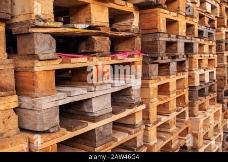 De nombreuses piles de palettes en bois d'occasion de type euro en entrepôt sont prêtes pour le recyclage. Contexte industriel. Gros plan. À L'Extérieur. Banque D'Images