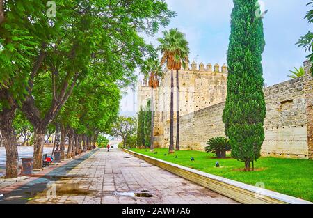 Promenez-vous dans la rue ombragée et profitez de la vue sur la forteresse mauresque de l'Alcazar avec d'énormes tours de guet et une rampart préservée, Jerez, Espagne Banque D'Images