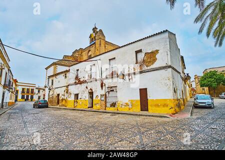 Bâtiment abandonné en shabby dans la rue Calle Alegria de la vieille ville avec vue sur le beffroi de l'église médiévale San Mateo (St Matthew) en arrière-plan, Jerez, Sp Banque D'Images