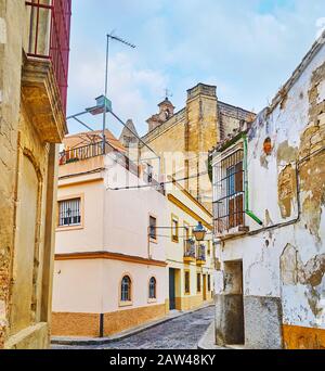 Promenez-vous dans les quartiers vivants de la vieille ville avec vue sur les petites maisons et le beffroi de pierre de l'église San Mateo (St Matthew) en arrière-plan, Jerez, Espagne Banque D'Images