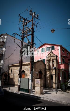 Une petite église dans le centre-ville de zakynthos, nichée dans une rue latérale, est coincée entre une grande sous-station électrique et un bâtiment. Banque D'Images