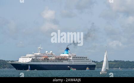 Massive Saga Sapphire paquebot au milieu de la Fal off Falmouth naine la terre et d'autres navires. Fumée de l'entonnoir. Banque D'Images