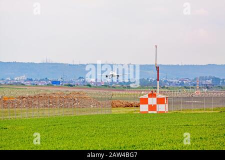 Stuttgart, Allemagne - 29 avril 2017 : avion en approche d'atterrissage - piste devant. Vue depuis la prairie verte. Banque D'Images