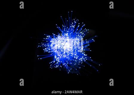 Fibre optique, concept de matériel de fil Internet, transporte des signaux lumineux à des fins de télécommunication. Les tubes en verre s'illuminent dans l'obscurité. Banque D'Images