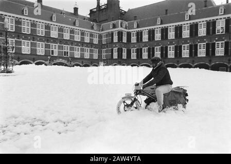 Les pompiers d'Amsterdam ont à la Haye Binnenhof recouvert d'une couche épaisse de mousse pour protester contre le 3.5 le garçon de livraison de journaux conduit son scooter par la mousse Date: 15 novembre 1983 lieu: Courtyard, La Haye, South Holland mots clés: Officiers, pompiers, roseaux, livreurs de journaux, salaire et prix Banque D'Images