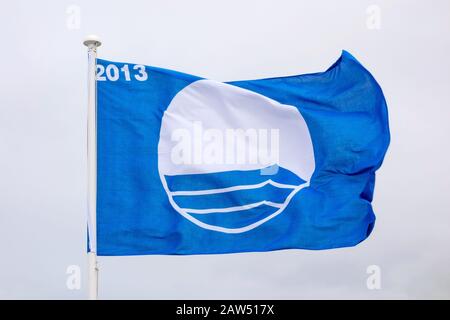 Drapeau bleu agitant. Le drapeau représente les meilleures plages d'Europe 2013 Porto Moniz, Madère, Portugal - 2 juin 2013: Waving blue Flag. Le support du drapeau Banque D'Images