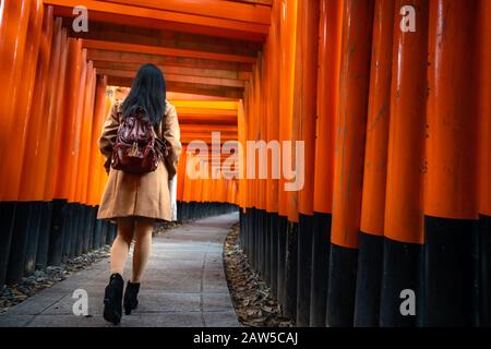 Une femme asiatique voyageur avec sac à dos marche et visite touristique à la célèbre destination Fushimi Inari Shrine à Kyoto, Japon. Le tourisme japonais, la vie de la nature Banque D'Images