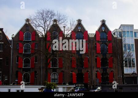 Amsterdam, PAYS-BAS - 26/1/20 - volets Rouges Sur un canal maison Banque D'Images