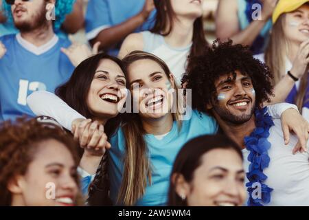 Groupe de fans regardant le match de football dans le stade. Groupe de fans de football argentins enthousiastes dans le stade pour regarder un match. Banque D'Images
