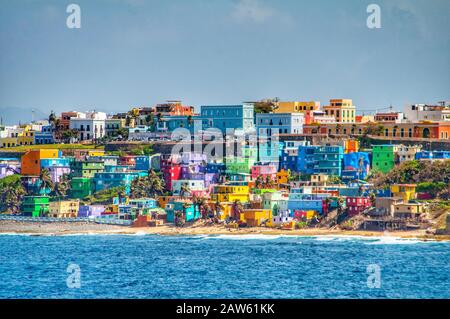 Des maisons colorées s'alignent sur la colline surplombant la plage de San Juan, Porto Rico Banque D'Images