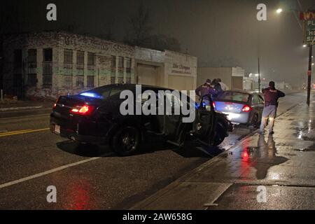 Les officiers de police spéciale de Detroit arrêtent un véhicule et parlent au conducteur lors d'une nuit de pluie à Detroit, Michigan, États-Unis Banque D'Images