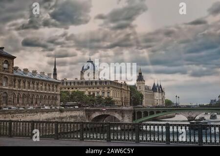 Vue du Pont d'Arcole du palais de la Cité, du Palais de Justice, du Palais de Justice et de la Conciergerie dans une lumière dramatique qui traverse les nuages Banque D'Images