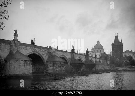 Pont Charles le matin brouillard, de la rive de la rivière sur Malá Strana photographié en noir et blanc - Karlův la plupart au-dessus de la Vltava, Prague. Banque D'Images