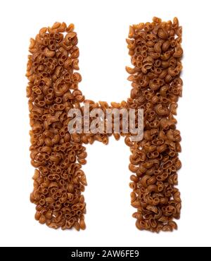 Lettre H de l'alphabet anglais à partir de pâtes sèches à base de farine d'amarante au sarrasin sur fond blanc isolé. Motif alimentaire en tubes macaroni. Banque D'Images