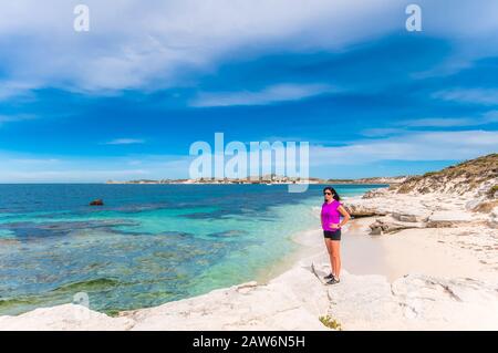 Une touriste féminine fait une pause lors de sa visite en vélo de rottnest Islan pour admirer les eaux turquoise et la magnifique plage dans une crique isolée. Banque D'Images