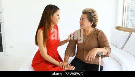 Gai femme prenant soin de sa grand-mère dans la chambre de lit à la maison Banque D'Images