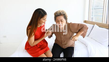 Gai femme prenant soin de sa grand-mère dans la chambre de lit à la maison Banque D'Images