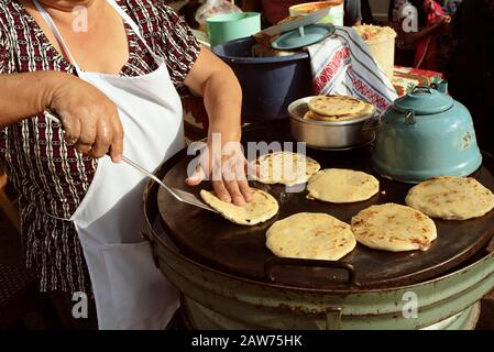 Une femme indigène cuisine des pupupusas traditionnelles (pain plat épais farci au fromage). Cuisine de rue à Antigua, Guatemala. Janvier 2019 Banque D'Images