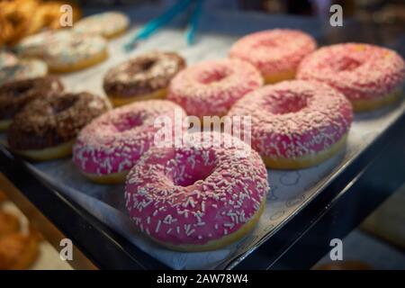 Beignets multicolores sur le comptoir du café. Banque D'Images