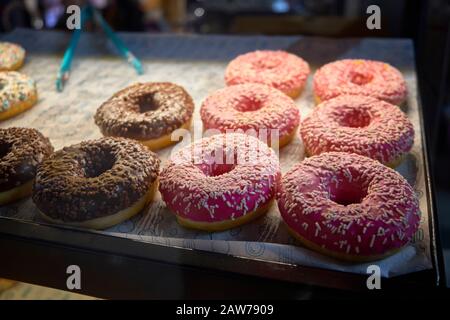 Beignets multicolores sur le comptoir du café. Banque D'Images