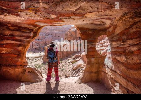 Voyageur femme posant à l'entrée d'un tombeau abandonné à Petra, Jordanie Banque D'Images