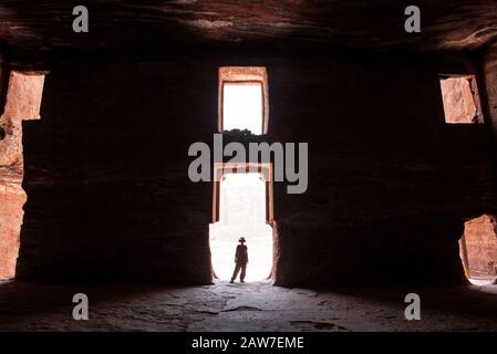 Silhouette d'une femme de voyage posant à l'entrée d'un tombeau royal abandonné à Petra, Jordanie Banque D'Images