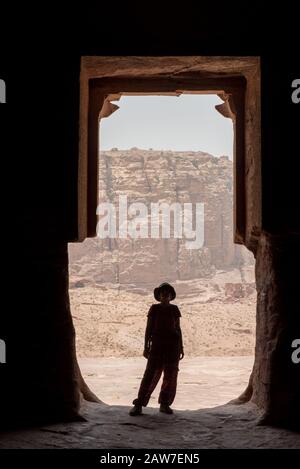 Silhouette d'une femme de voyage posant à l'entrée d'un tombeau royal abandonné à Petra, Jordanie Banque D'Images