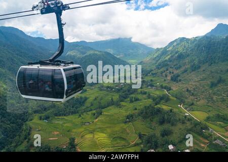 Sapa, Vietnam - 20 août 2017: Cabine de téléphérique avec des touristes qui voyagent sur des terrasses pittoresques de riz vert à Sapa, Vietnam Banque D'Images