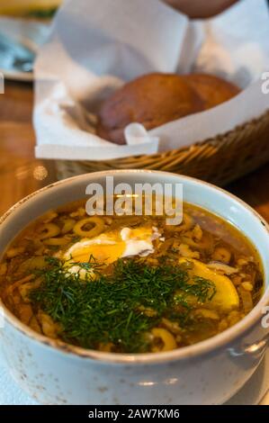 Gros plan sur la soupe de borscht ou de borscht dans un bol rustique garni de crème aigre et de aneth Banque D'Images