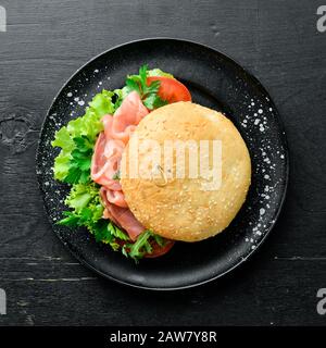 Hamburger au saumon, aux tomates et aux oignons. Petit Déjeuner. Vue de dessus. Espace libre pour votre texte. Banque D'Images