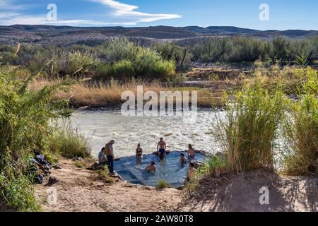 Baigneurs à la piscine de Hot Springs au bord de Rio Grande, côté mexicain de l'autre côté de la rivière, désert de Chihuahuan, parc national de Big Bend, Texas, États-Unis Banque D'Images