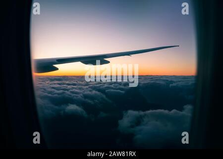 Lever du soleil à une altitude de dix mille mètres. Vue du beau coucher du soleil sur les nuages de la fenêtre de l'avion pendant le vol. À l'intérieur du Banque D'Images