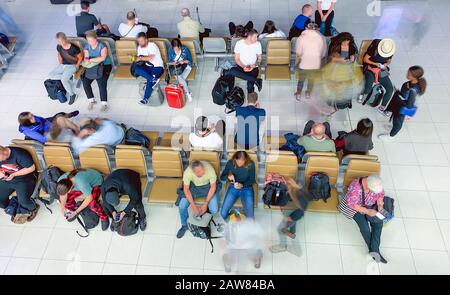 Touristes en attente de vol dans le hall du terminal, vue brouillée des personnes en mouvement. Banque D'Images