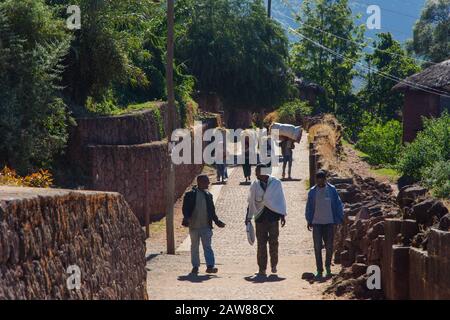Lalibela, Ethiopie - Nov 2018: Les gens marchant et groupe de femmes transportant du foin dans la rue de Lalibela, Ethiopie Banque D'Images