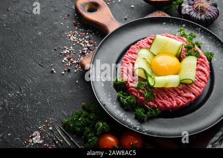 Tartare de boeuf avec jaune d'oeuf. Cuisine traditionnelle. Vue de dessus. Espace libre pour votre texte. Banque D'Images