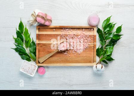 Cosmétiques à base de roses. Savon et sel de mer sur une table blanche. Vue de dessus. Espace libre pour votre texte. Banque D'Images