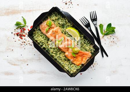 Filet de poisson cuit à la sauce tomate avec sarrasin vert et épinards. Livraison du plat du restaurant. Vue de dessus. Espace libre pour votre texte. Banque D'Images