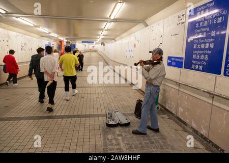 Le buker asiatique; un homme jouant un violon dans le métro, Kowloon, Hong Kong Asie Banque D'Images