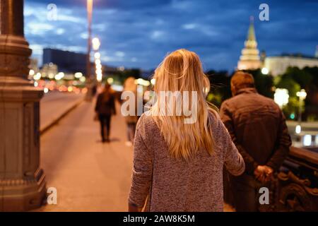 Suivez-moi - la jeune femme tire la main des hommes sur la rue la nuit. Banque D'Images