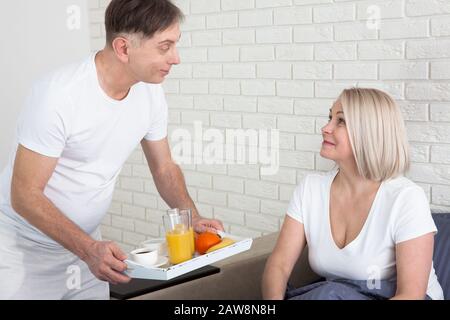 Couple romantique heureux ayant le petit déjeuner au lit à la maison Banque D'Images