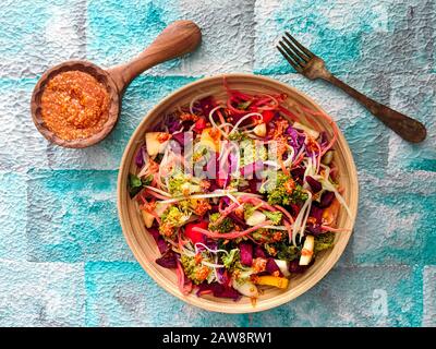 Salade fraîche de brocoli, carottes, pomme, chou rouge, betteraves, radis avec sauce aux arachides au sésame. Sans gluten, végétalien, alimentation, santé, café, restaurant Banque D'Images