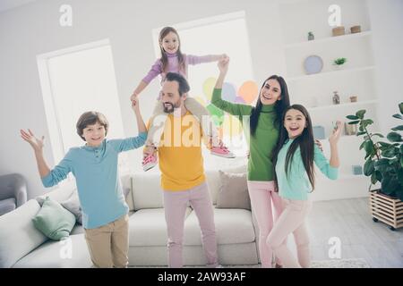 Une harmonie parfaite et douilleuse les gens aiment la fête de la famille de la femme papa maman tenir main porter jeune fille piggyback trois enfants de la préadolescence dans la maison Banque D'Images